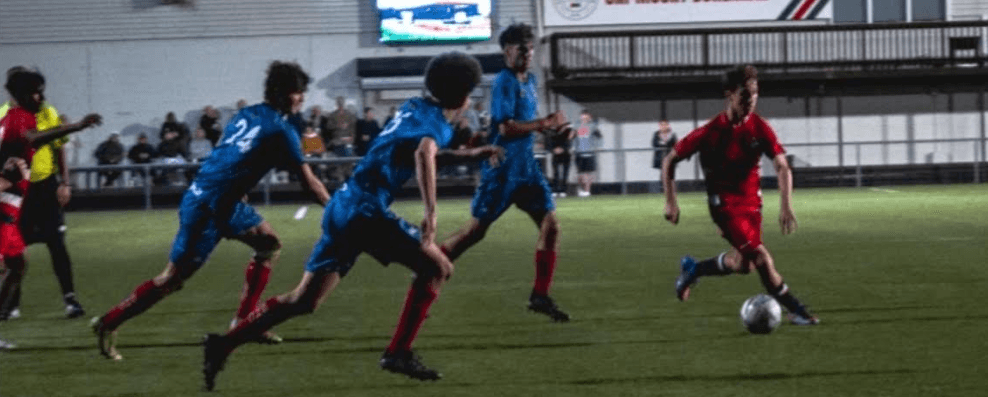 Chasing the ball down the wing during a night football match