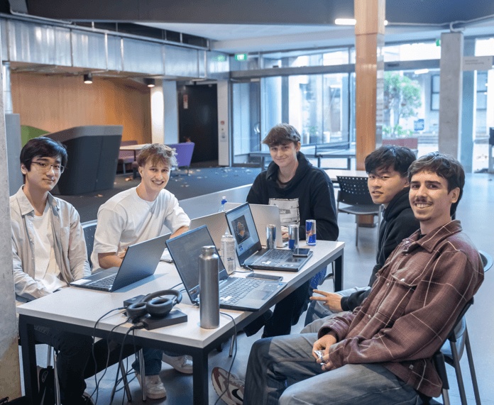 Working on laptops with friends in a university study space